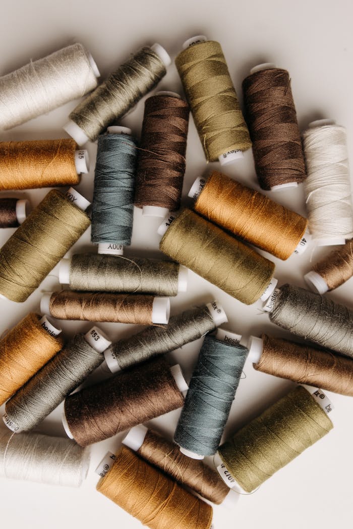 Overhead view of various spools of colorful sewing threads arranged artistically.